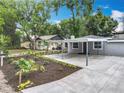 Gray single-story home featuring a covered parking area, complimented by a well-manicured front yard at 1414 Beaver Pl, Orlando, FL 32806