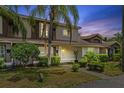 Charming townhouse exterior with tropical landscaping and a well-maintained lawn at twilight at 14820 Laguna Beach Cir, Orlando, FL 32824