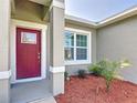 The front door is red with white trim, complemented by a small palm tree in fresh mulch at 16253 Sw 29Th Court Rd, Ocala, FL 34473