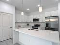 Modern kitchen boasts white cabinets, stainless appliances and an island with pendant lighting at 16253 Sw 29Th Court Rd, Ocala, FL 34473