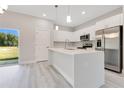 Bright kitchen boasts stainless steel appliances, white cabinets, stone countertops, and opens to the backyard at 16253 Sw 29Th Court Rd, Ocala, FL 34473