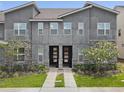 Modern townhome exterior features a black front door and manicured front lawn at 1632 Tropical Palms Circle, Kissimmee, FL 34747