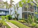 Two-story condo building featuring a screened-in balcony and lush landscaping at 2349 Oak Park Way # 107, Orlando, FL 32822