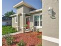 Inviting front entrance with modern stucco accents, colorful landscaping, and stylish outdoor lighting at 2531 Sw 167Th Loop, Ocala, FL 34473