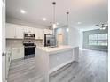 Modern kitchen featuring stainless steel appliances, a center island with sink and stylish gray flooring at 2531 Sw 167Th Loop, Ocala, FL 34473