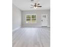 Bright living room featuring modern gray flooring, large windows, and a ceiling fan at 2531 Sw 167Th Loop, Ocala, FL 34473