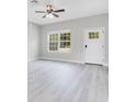 Bright living room featuring modern gray flooring, large windows, and a ceiling fan at 2531 Sw 167Th Loop, Ocala, FL 34473