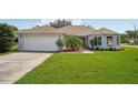 Beautiful single-story home featuring a well-manicured lawn, two-car garage, and inviting curb appeal on a sunny day at 26609 Bull Run, Leesburg, FL 34748