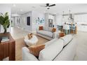 Bright, open-concept living room with tile floors, modern furnishings, and an adjacent kitchen at 2681 Ginseng Ivy St, Apopka, FL 32703