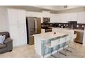 Modern kitchen with stainless steel appliances, white cabinets, and a center island with bar stool seating at 3150 Paradox Cir # 102, Kissimmee, FL 34746