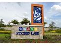 Beautiful community sign reading 'Storey Lake' surrounded by lush landscaping and colorful flowers at 3150 Paradox Cir # 102, Kissimmee, FL 34746
