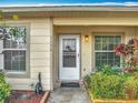 Inviting front entrance with a white door, well-maintained landscaping, and bright windows on either side at 3208 W Tower Ct, Kissimmee, FL 34741