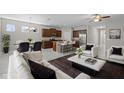 Open floor plan showcasing the living room, dining area, and kitchen with stainless steel appliances and a center island at 405 E Freesia Ct, Deland, FL 32724