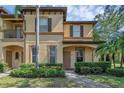 Charming two-story townhome with a manicured lawn and inviting front porch at 4143 Calabria Ave, Davenport, FL 33897