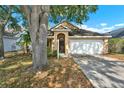 Inviting single Gathering home with a two-car garage, mature landscaping, and an arched entryway at 4406 Brookstone Ct, Orlando, FL 32826