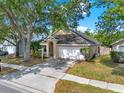 Front of a single Gathering home featuring mature landscaping, sidewalks, and a large front yard at 4406 Brookstone Ct, Orlando, FL 32826