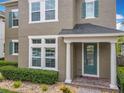 Inviting home exterior with manicured landscaping, decorative fence, and a charming front porch with stately white columns at 473 Oviedo Blvd, Oviedo, FL 32765