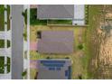 Overhead view of a home with a neutral-toned roof, a well-maintained yard, and neighborhood street at 523 Tortugas St, Haines City, FL 33844