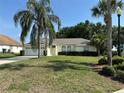 Inviting single-story home featuring mature landscaping, a spacious front yard, and an attached two-car garage at 5604 Loma Vista W Dr, Davenport, FL 33896