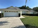 Attractive home showcasing an attached two-car garage, a paved driveway, and lush green lawn at 5604 Loma Vista W Dr, Davenport, FL 33896