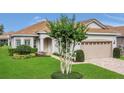 Charming home featuring a two-car garage, neutral paint, brick driveway, manicured lawn, and mature landscaping at 578 Newhall Ln, Debary, FL 32713