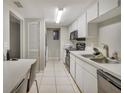 Galley style kitchen featuring white cabinets and modern appliances at 5833 La Costa Dr # S, Orlando, FL 32807