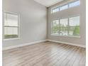 A serene living space with large windows, providing natural light and showcasing the light wood flooring at 7789 Nemours Pkwy, Orlando, FL 32827