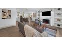 Bright living room featuring an open floor plan, fireplace, and modern decor with natural wood flooring at 7813 Delphia St, Orlando, FL 32807