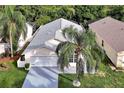 Aerial shot of home showing mature landscaping, neutral paint, and driveway at 941 Clear Creek Cir, Clermont, FL 34714