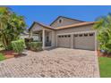 Charming home with a well-manicured lawn, brick paved driveway, neutral paint, shutters, and an attached garage at 9836 Lake District Ln, Orlando, FL 32832