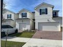 Inviting exterior view of modern two-story home with brick driveway, well maintained lawn, and attached garage at 1190 Seaside Mist Trl, Kissimmee, FL 34747