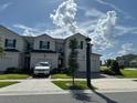 Inviting two-story townhome with manicured lawn, private driveway, and beautiful blue sky at 1190 Seaside Mist Trl, Kissimmee, FL 34747