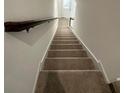 Clean, carpeted staircase leading upstairs with a wooden handrail and white walls on either side at 1190 Seaside Mist Trl, Kissimmee, FL 34747