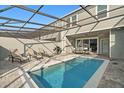 Inviting screened-in pool area, complete with lounge chairs, grill, and patio furniture at 1283 Blue Paradise Way, Clermont, FL 34714