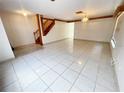 Open-concept living area with tile floors, stairway access, and neutral wall colors creating a welcoming atmosphere at 13046 Prairie Meadows Dr, Orlando, FL 32837