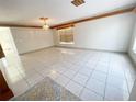 Spacious living room featuring tile flooring, wood trim accents, and ample natural light from the window at 13046 Prairie Meadows Dr, Orlando, FL 32837