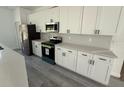A well-equipped kitchen featuring white cabinets, modern stainless steel appliances, and quartz countertops at 13265 Sw 85Th Cir, Ocala, FL 34473