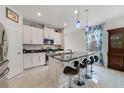 Bright kitchen boasts white cabinets, a black marble countertop island, and stylish pendant lighting at 1396 Riley Cir, Deland, FL 32724