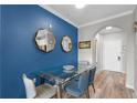 Chic dining room with blue accent wall, a glass top table, stylish chairs, and decorative mirrors at 14200 Avalon Rd # 409, Winter Garden, FL 34787