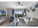 Cozy living room boasts a comfortable seating area, a ceiling fan, and a glass door leading to an outdoor balcony at 14200 Avalon Rd # 409, Winter Garden, FL 34787