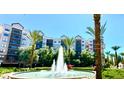 Multi-story building with balconies, palm trees and a central water fountain at 14501 Grove Resort Ave # 3636, Winter Garden, FL 34787