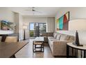 Comfortable living room with stylish furniture, a balcony view, and modern artwork on the wall at 14501 Grove Resort Ave # 3636, Winter Garden, FL 34787