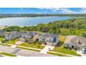 Aerial view of a well-manicured neighborhood, highlighting the home's proximity to a serene lake and lush green spaces at 16410 Good Hearth Blvd, Clermont, FL 34711