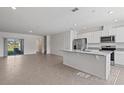 Open-concept kitchen and living space features stainless appliances, granite countertops, and ample natural light at 17081 Water Spring Blvd, Winter Garden, FL 34787