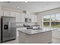 Modern kitchen featuring granite countertops, stainless steel appliances, and white cabinetry at 17081 Water Spring Blvd, Winter Garden, FL 34787