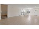 Spacious living room showcasing tile flooring, staircase, and bright, open layout leading to the kitchen at 17081 Water Spring Blvd, Winter Garden, FL 34787