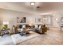 Inviting living room showcasing neutral tones, stylish furniture, a decorative mirror, and adjacent dining area at 17081 Water Spring Blvd, Winter Garden, FL 34787