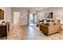 Bright living room featuring neutral walls, tile floors, contemporary furniture, and a sliding glass door to the patio at 17081 Water Spring Blvd, Winter Garden, FL 34787