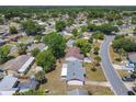 Neighborhood view of a cozy, single-story home with a large backyard surrounded by lush green trees at 186 Tulpan Dr, Kissimmee, FL 34743