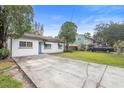 Quaint home featuring a spacious driveway, inviting curb appeal, and lush green lawn at 2123 Weber St, Orlando, FL 32803